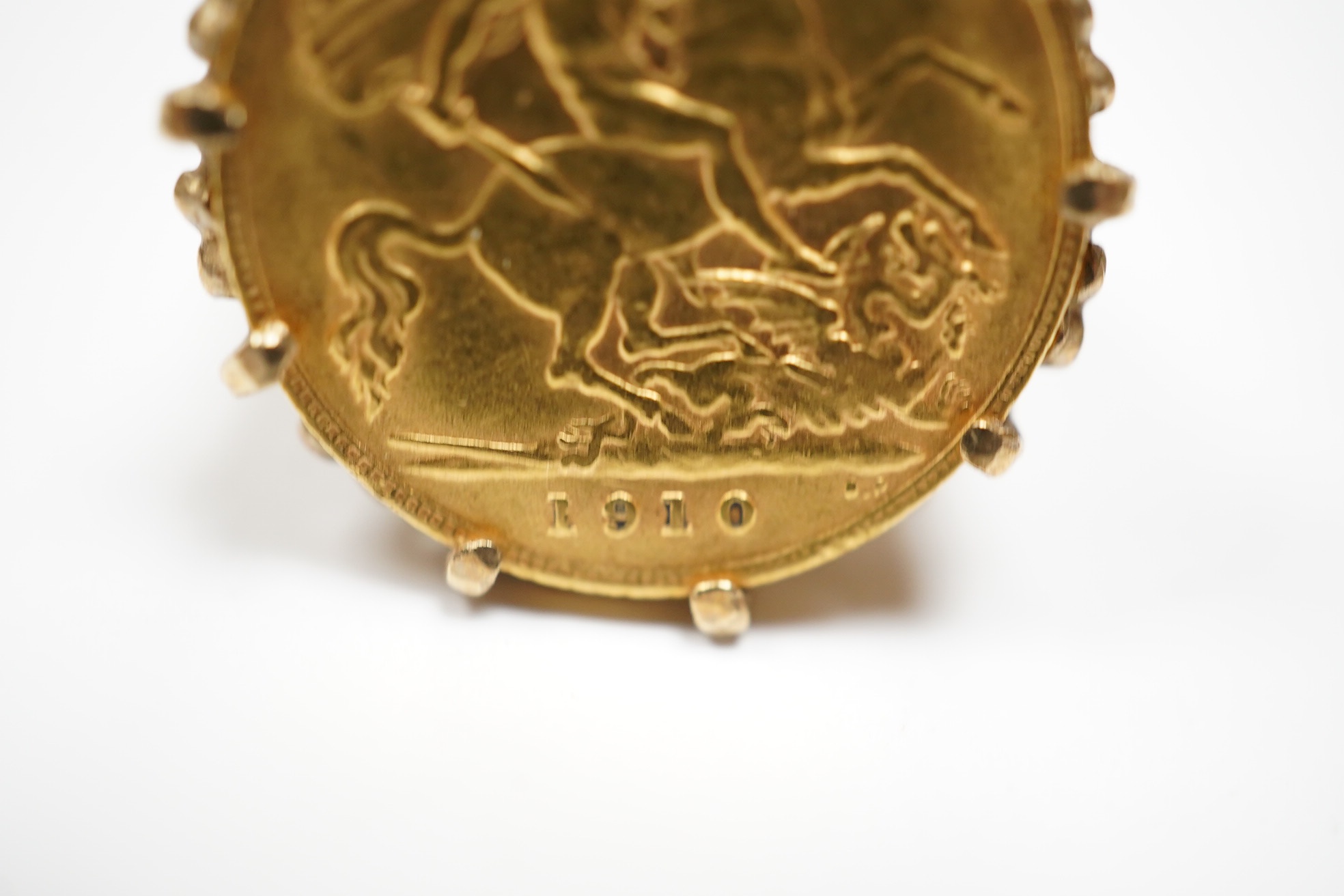 A George V gold half sovereign, in a later pierced and carved 9ct god ring mount, size P, gross weight 10 grams. Condition - fair.